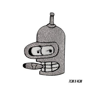May include: Embroidered patch featuring a cartoon robot character with a cigar in its mouth. The robot is gray with black and white details. The patch measures 7cm x 4cm.