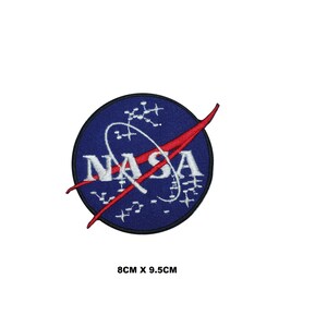 May include: A blue and red embroidered NASA patch with a white circle and the word "NASA" in white lettering. The patch is 8 cm by 9.5 cm.