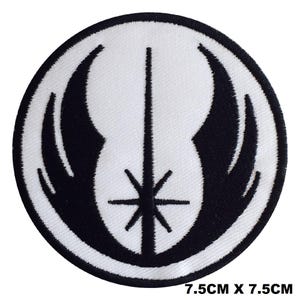 May include: A circular embroidered patch featuring a black Jedi Order symbol on a white background. The design includes a central vertical line intersected by a starburst shape, flanked by two curved wing-like elements. The patch measures 7.5cm x 7.5cm.