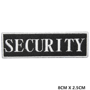Peut inclure: Écusson brodé noir avec du texte blanc qui dit "SECURITY". L'écusson mesure 8 cm sur 2,5 cm.