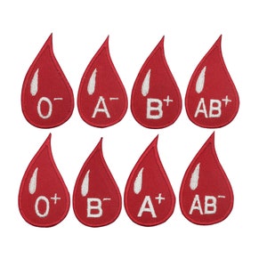 Könnte beinhalten: Acht rote, bügelbare Aufnäher in Form von Blutstropfen mit weißen, gestickten Blutgruppen: O-, A-, B+, AB+, O+, B-, A+, AB-.