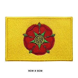 Könnte beinhalten: Ein gelber gestickter Aufnäher mit einer roten Rose und grünen Blättern. Die Rose hat eine gelbe Mitte mit einem grünen Stern. Der Aufnäher ist 9 cm x 6 cm groß.