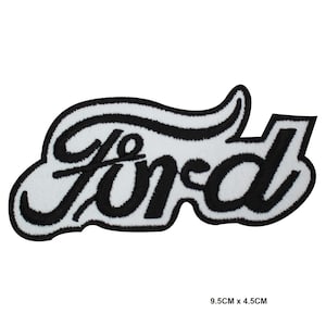 May include: An embroidered patch with the word "Ford" in black script on a white background. The patch has a black border. The patch measures 9.5cm x 4.5cm.