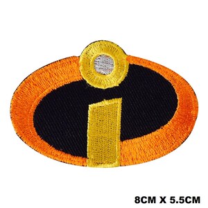 May include: An oval-shaped embroidered patch featuring a black background with an orange border. The design includes a yellow letter i with a yellow dot above it, which has a silver center. The patch measures 8 cm by 5.5 cm in total size.