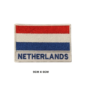 May include: Embroidered patch of the Netherlands flag, with red, white, and blue horizontal stripes. The word "NETHERLANDS" is embroidered in blue at the bottom. The patch measures 9cm x 6cm.