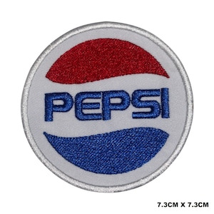 May include: A white, round embroidered patch with the Pepsi logo. The logo features a red and blue wave design with the word "PEPSI" in blue lettering.