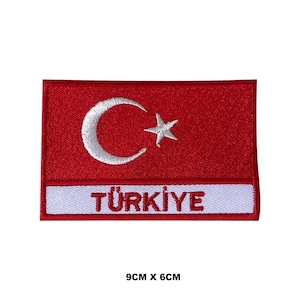 Può includere: Toppa ricamata con la bandiera turca con una mezzaluna e una stella bianche su sfondo rosso. La parola "TÜRKİYE" è scritta in bianco su uno stendardo bianco sotto la bandiera. La toppa misura 9 cm per 6 cm.