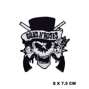 May include: Black and white embroidered patch featuring the Guns N' Roses logo. The logo includes a skull with a top hat, crossed pistols, and the band's name in a banner.