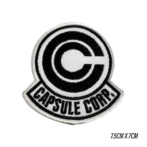 Op de afbeelding: Een zwart-wit geborduurde patch met het Capsule Corp.-logo. Het ontwerp toont een grote "C" en de tekst "CAPSULE CORP.". De patch is 7,5 cm x 7 cm groot.