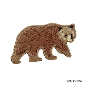 Può includere: Toppa ricamata raffigurante un orso bruno che cammina verso sinistra. L'orso ha un muso marrone chiaro e dettagli marrone scuro. La toppa misura 8 cm x 4,5 cm. Adatta per abbigliamento o accessori.