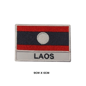 May include: Embroidered iron-on patch featuring the flag of Laos. The patch is red, white, and blue with the text "LAOS" below the flag. The patch measures 9 inches by 6 inches.