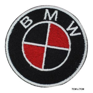 Puede incluir: Parche redondo con el logotipo de BMW en negro y rojo con letras bordadas en blanco. El parche mide 7 cm x 7 cm. El logotipo de BMW presenta un círculo segmentado en negro y rojo con las letras "BMW" en blanco.