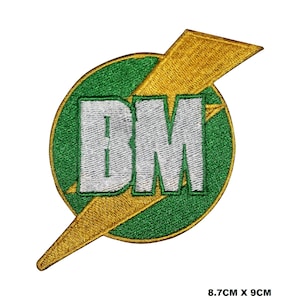 May include: Green and gold embroidered patch with the letters "DM" in white inside a lightning bolt. The patch is 8.7 cm by 9 cm.
