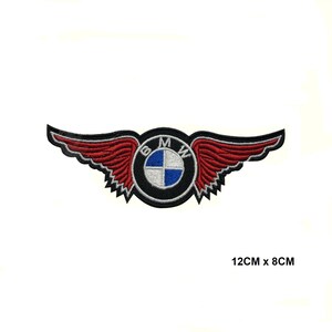 Peut inclure: Écusson brodé avec le logo BMW et des ailes rouges. L'écusson est noir avec un emblème circulaire au centre, affichant le logo BMW en bleu, blanc et noir. Les ailes sont rouges avec une bordure noire. Mesure 12 cm x 8 cm.