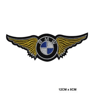 Könnte beinhalten: Gestickter Aufnäher mit dem BMW-Logo und Flügeldesign. Der Aufnäher ist schwarz mit goldenen Flügeln und einem kreisförmigen Emblem mit blauen und weißen Segmenten. Die Abmessungen betragen 12 cm x 8 cm.