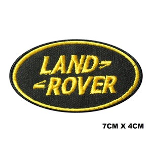 Peut inclure: Écusson ovale noir avec l'inscription « LAND - ROVER » en jaune. Le patch, bordé de jaune, mesure 7 cm sur 4 cm.