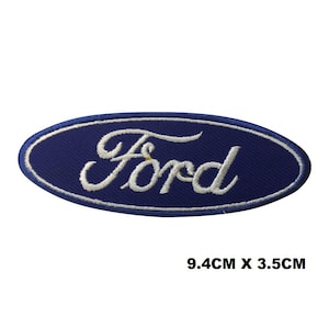 May include: Embroidered patch with the Ford logo in white script on a navy blue oval. The patch measures 9.4cm x 3.5cm. The patch has a white border. The text 'Ford' is in a cursive font.