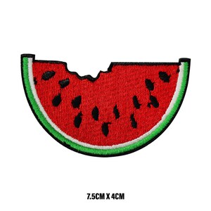 May include: A red watermelon slice with black seeds and a green rind. The watermelon is partially eaten, with a bite taken out of the top. The watermelon is 7.5 inches by 4 inches.