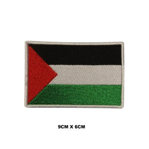 May include: An embroidered Palestinian flag patch with a red triangle, black, white, and green stripes. The patch is 9 cm by 6 cm.