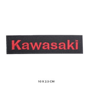 Könnte beinhalten: Ein rechteckiger gestickter Aufnäher mit schwarzem Hintergrund und dem in roten Buchstaben gestickten Wort Kawasaki. Der Aufnäher misst 10 cm mal 2,5 cm, wie durch den unter dem Artikel gedruckten Text angegeben, eine Standardgröße für Kleidung.