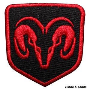 Op de afbeelding: Een zwart en rood geborduurde patch met het Dodge ram-logo. De patch is schildvormig met een rode rand en een rood ramkopontwerp op een zwarte achtergrond. Afmetingen: 7,5 cm x 7,5 cm.