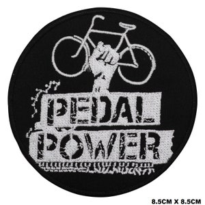 May include: Black and white embroidered patch with a bicycle and a raised fist, with the text "PEDAL POWER" in a distressed font.
