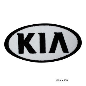 May include: An embroidered patch with the KIA logo. The logo is black on a white oval background, with a black border. The patch measures approximately 10cm x 5cm.