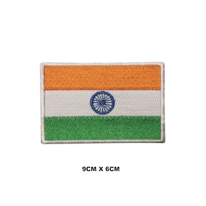 May include: An embroidered iron-on patch of the Indian flag. The flag is rectangular and features three horizontal stripes: saffron, white, and green. The white stripe has a blue wheel in the center. The patch measures 9 cm by 6 cm.