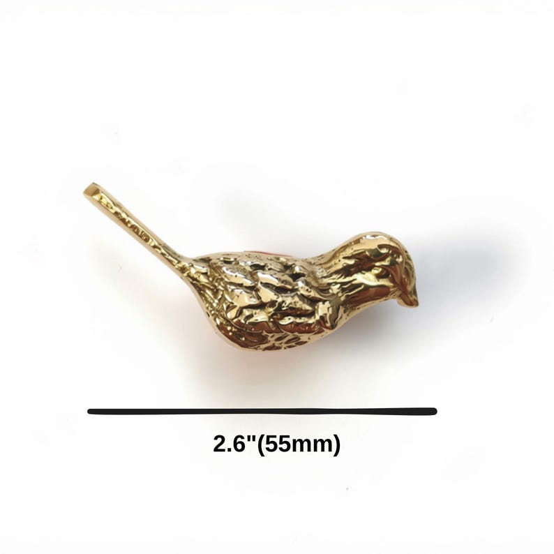 K&ouml;nnte beinhalten: Eine goldfarbene Metallvogel-Figur mit einem strukturierten Federmuster auf dem K&ouml;rper und einem langen Schwanz. Der Vogel ist &uuml;ber einer schwarzen horizontalen Linie positioniert, unter der der Text 2.6"(55mm) steht, was eine L&auml;nge von 55 mm angibt.