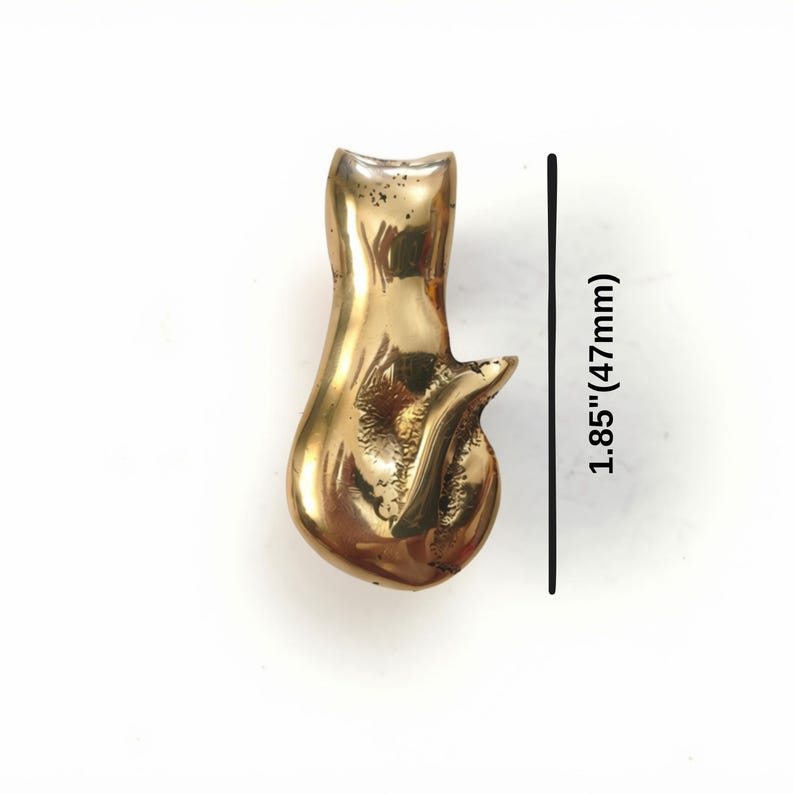K&ouml;nnte beinhalten: Eine polierte, goldfarbene Katzenfigur aus Metall mit einer glatten, reflektierenden Oberfl&auml;che und einem geschwungenen Schwanz. Eine schwarze vertikale Linie neben dem Objekt zeigt eine H&ouml;he von 47 mm an, was 1,85 Zoll entspricht.