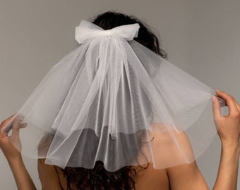 Veil bow made of soft tulle in two layers with a bow and a hairpin for attaching to the hair.