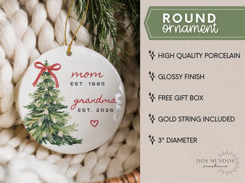 May include: A round white porcelain ornament with a 3-inch diameter, featuring a watercolor Christmas tree with a red bow, the text "mom EST. 1995" and "grandma EST. 2026" in red, a small red heart, and a gold string for hanging.