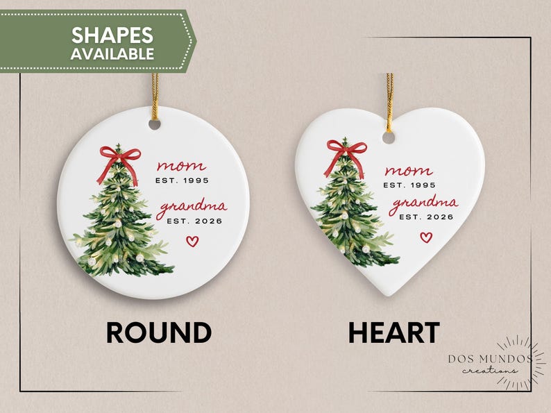 May include: Two white ceramic ornaments, one round and one heart-shaped, each featuring a watercolor Christmas tree with a red bow, the text mom EST. 1995, grandma EST. 2026, and a small red heart. Both ornaments hang from gold strings.