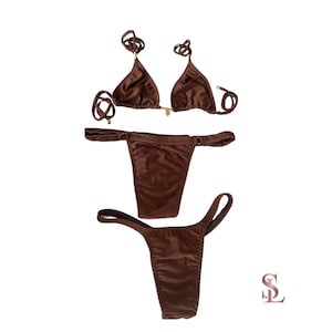 May include: A brown bikini set with a triangle top and adjustable straps, and a thong-style bottom. The swimwear is made of a smooth, shiny fabric and is displayed on a white background. The set includes a matching bottom.