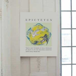 May include: A white and black print with a quote by Epictetus, "Man is not worried by real problems so much as by his imagined anxieties about real problems." The print features two fish swimming in a circle on a yellow and blue background.