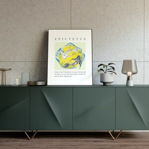 May include: A green cabinet with gold legs and a quote by Epictetus on a framed print above it. The quote reads "Man is not worried by real problems so much as by his imagined anxieties about real problems."