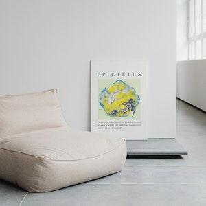May include: A beige bean bag chair sits in front of a white wall with a poster featuring a quote by Epictetus. The poster has a light green background with a yellow and blue abstract design.