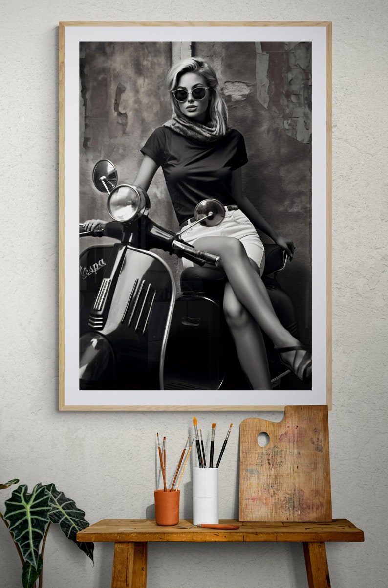 May include: A black and white photo of a woman wearing sunglasses and a scarf, sitting on a vintage Vespa scooter. The background is a textured wall.