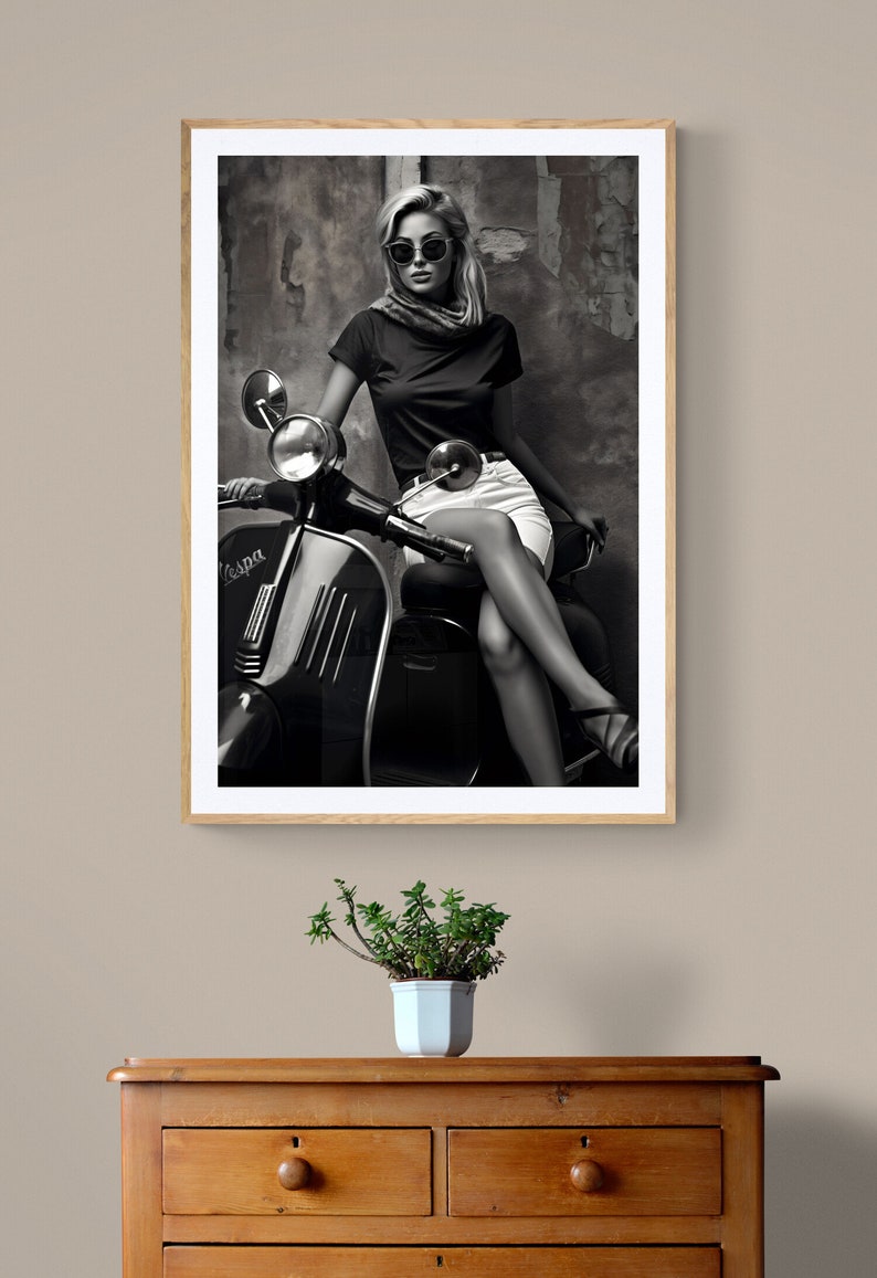 May include: Black and white photograph of a woman wearing sunglasses and a white skirt, sitting on a vintage Vespa scooter.