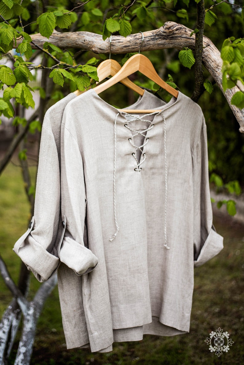 Linen shirt. Long sleeves that can be rolled up.
It fastens with a metal antique clasp.