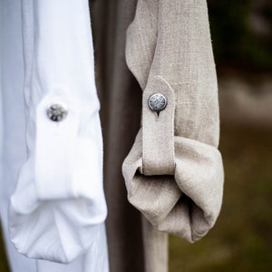 Linen shirt. Long sleeves that can be rolled up.
It fastens with a metal antique clasp.