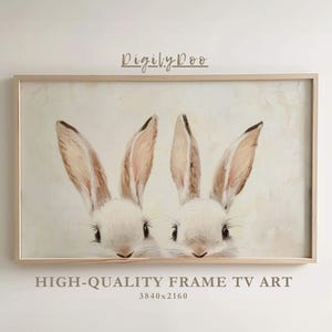 May include: A framed print of two white bunnies with brown ears, looking at the viewer. The print is in a light wood frame and has a white background.
