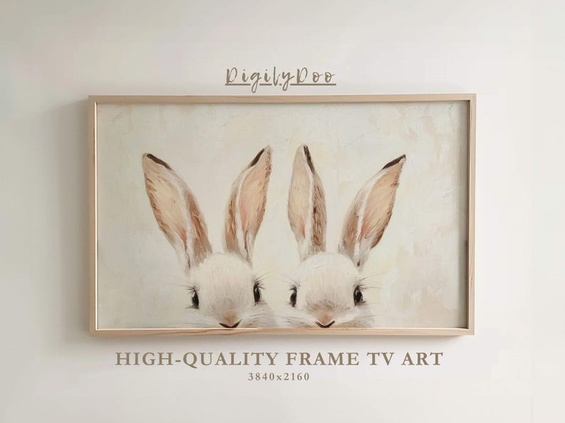 May include: A framed print of two white bunnies with brown ears, looking at the viewer. The print is in a light wood frame and has a white background.
