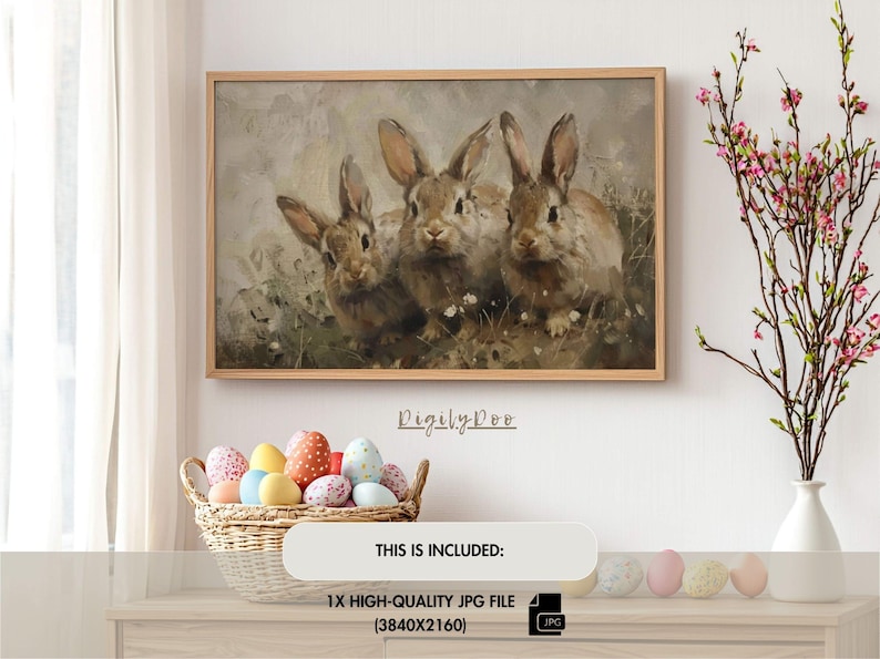 May include: A painting of three brown rabbits with white fur on their chests. The rabbits are sitting in a field of green grass and white flowers. The painting is framed in a light brown wood frame.