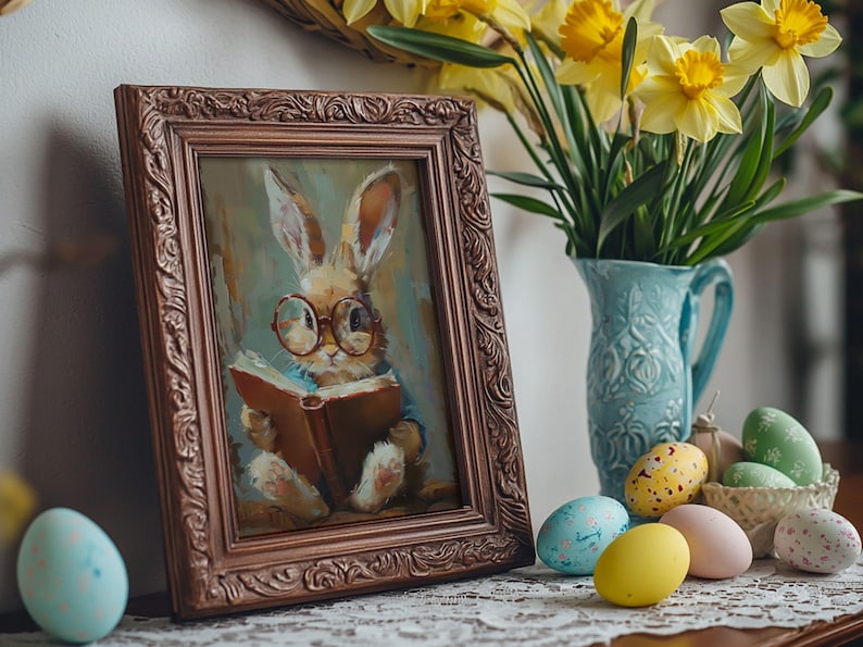 Puede incluir: Una pintura enmarcada de un conejo marr&oacute;n con gafas leyendo un libro. La pintura est&aacute; rodeada de un marco de madera marr&oacute;n con tallas intrincadas. La pintura est&aacute; sentada sobre una mesa con un jarr&oacute;n de narcisos amarillos y huevos de Pascua.