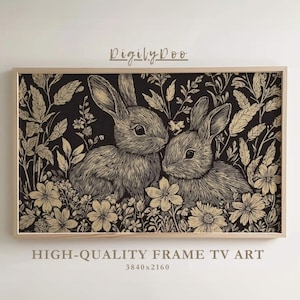 May include: A framed print of two rabbits in a field of flowers. The rabbits are drawn in a black and white style, with a gold overlay. The background is black.