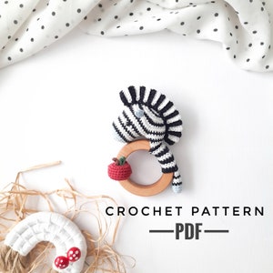Puede incluir: Patrón de crochet para un sonajero de cebra con una manzana roja. El patrón está disponible para descargar en PDF. CROCHET PATTERN - PDF