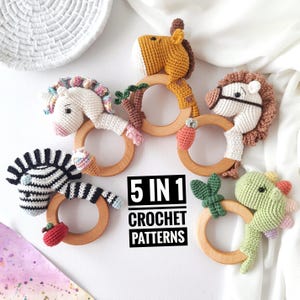 Può includere: Cinque schemi all'uncinetto per morsi per bambini, ognuno con un animale diverso: una zebra, un unicorno, una giraffa, un cavallo e un dinosauro. I morsi sono attaccati ad anelli di legno.