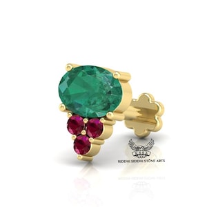 May include: A gold nose ring with a large green oval gemstone and smaller red round gemstones. The nose ring is designed to be worn on the side of the nose.