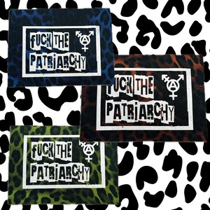Könnte beinhalten: Drei rechteckige Stoffaufnäher mit Leopardenmuster in Blau, Braun und Grün. Jeder Aufnäher zeigt den weißen Schriftzug FUCK THE PATRIARCHY in ausgeschnittenem Buchstabenstil sowie ein weißes, geschlechterinklusives Anarchie-Symbol.